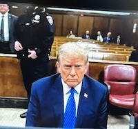 Screenshot of April 21, 2024 news report showing Donald Trump at the defense table at one of his recent court appearances